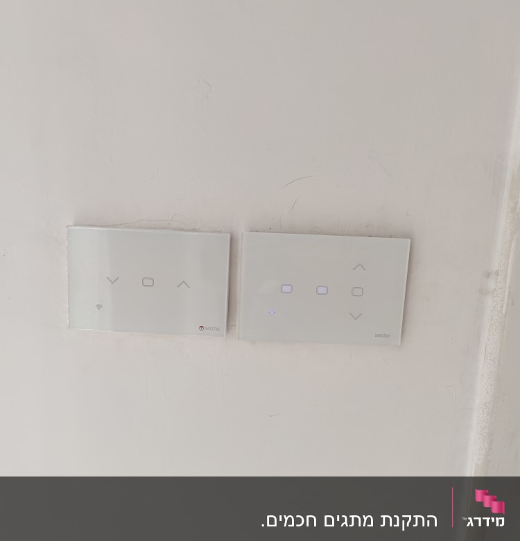 שני מתגי חשמל חכמים על קיר לבן